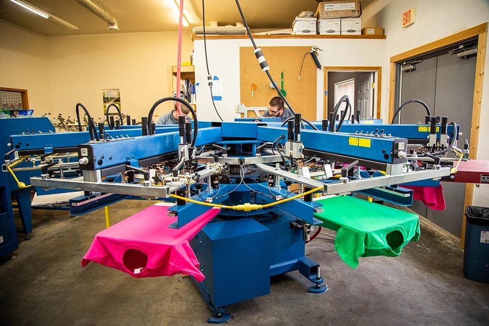 Our press team setting up a run — proofing and registration happen before full production starts. — custom apparel, Grocott Ink & Thread